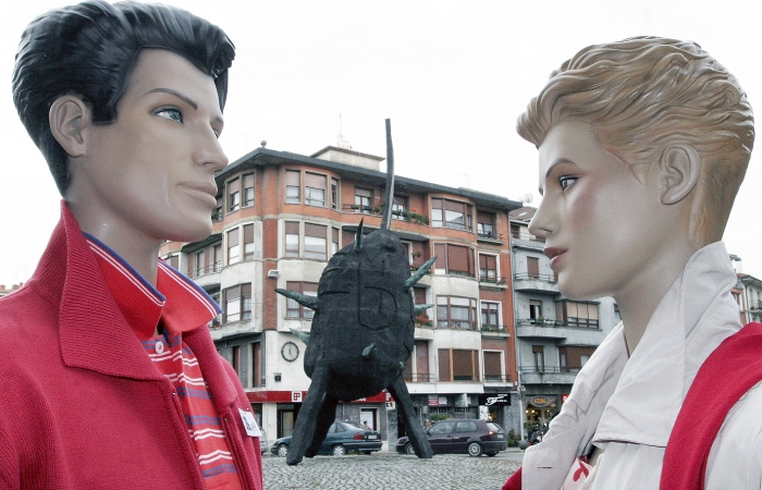 Dos maniquies, cortesia para la fotografia de la tienda Tuiyo miran la escultura de Andres Nagel en Zornotza, La Patata